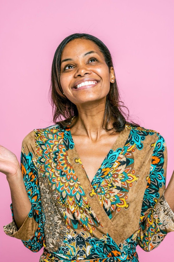 Mulher sorrindo em fundo rosa